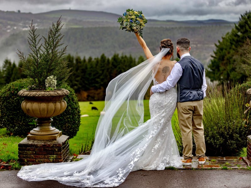 winter's day wedding showing bride in a a full lace dress with billowing veil